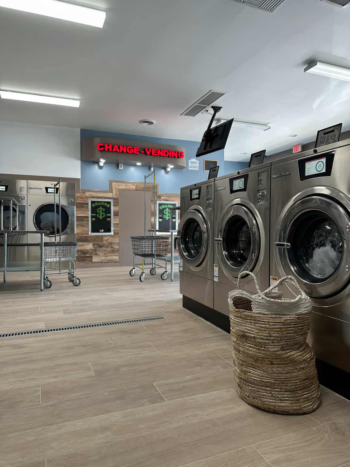 ECP Coin Laundry Arcadia interior showing rows of brand new Speed Queen washing machines with modern change station and clean environment